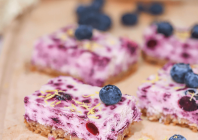 Slices of high protein blueberry cheesecake on a chopping board