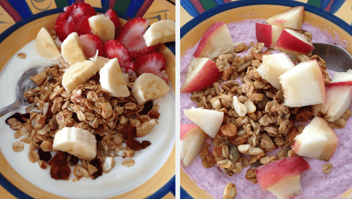 Two brekkie yoghurt bowls topped with muesli and fruit