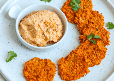 Carrot fritters on a platter with sweet potato hummus
