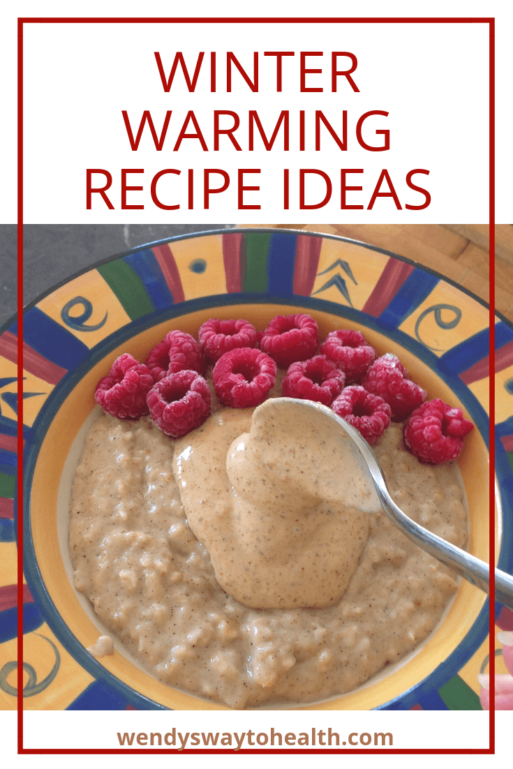 a bowl of porridge topped with raspberries and a spoonful of nut butter