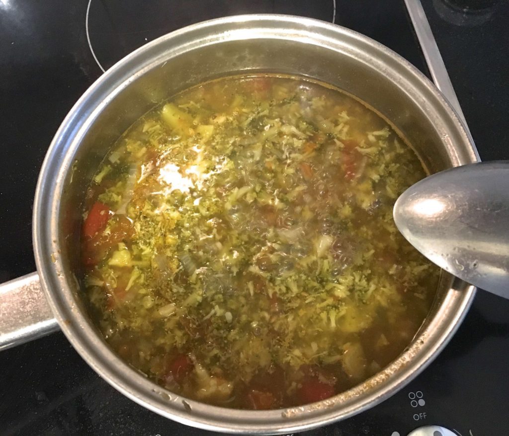 Broccoli and tomato soup in a saucepan, cooking on the stove