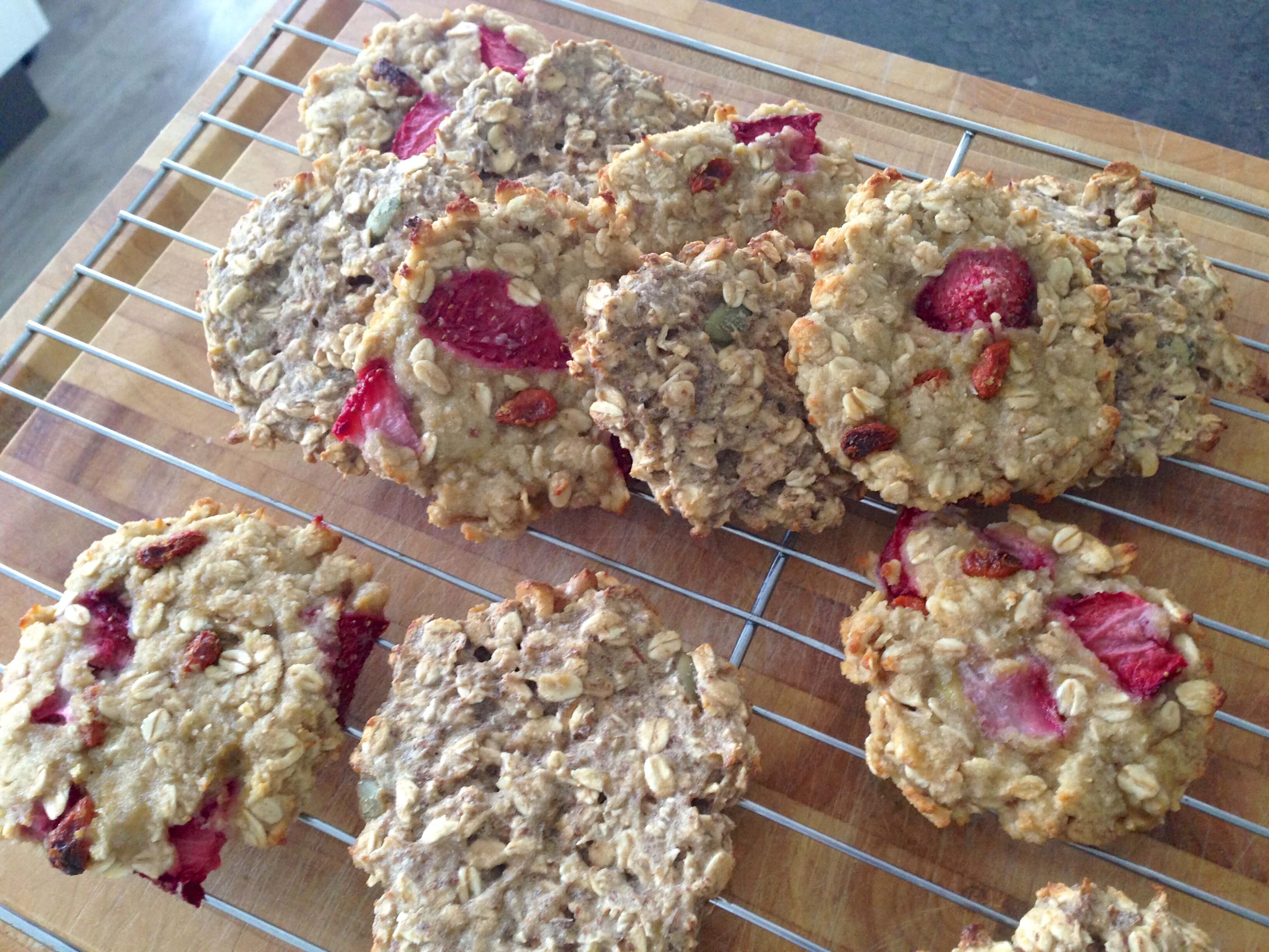 Oat cookies with strawberries and seeds on a cooling rack