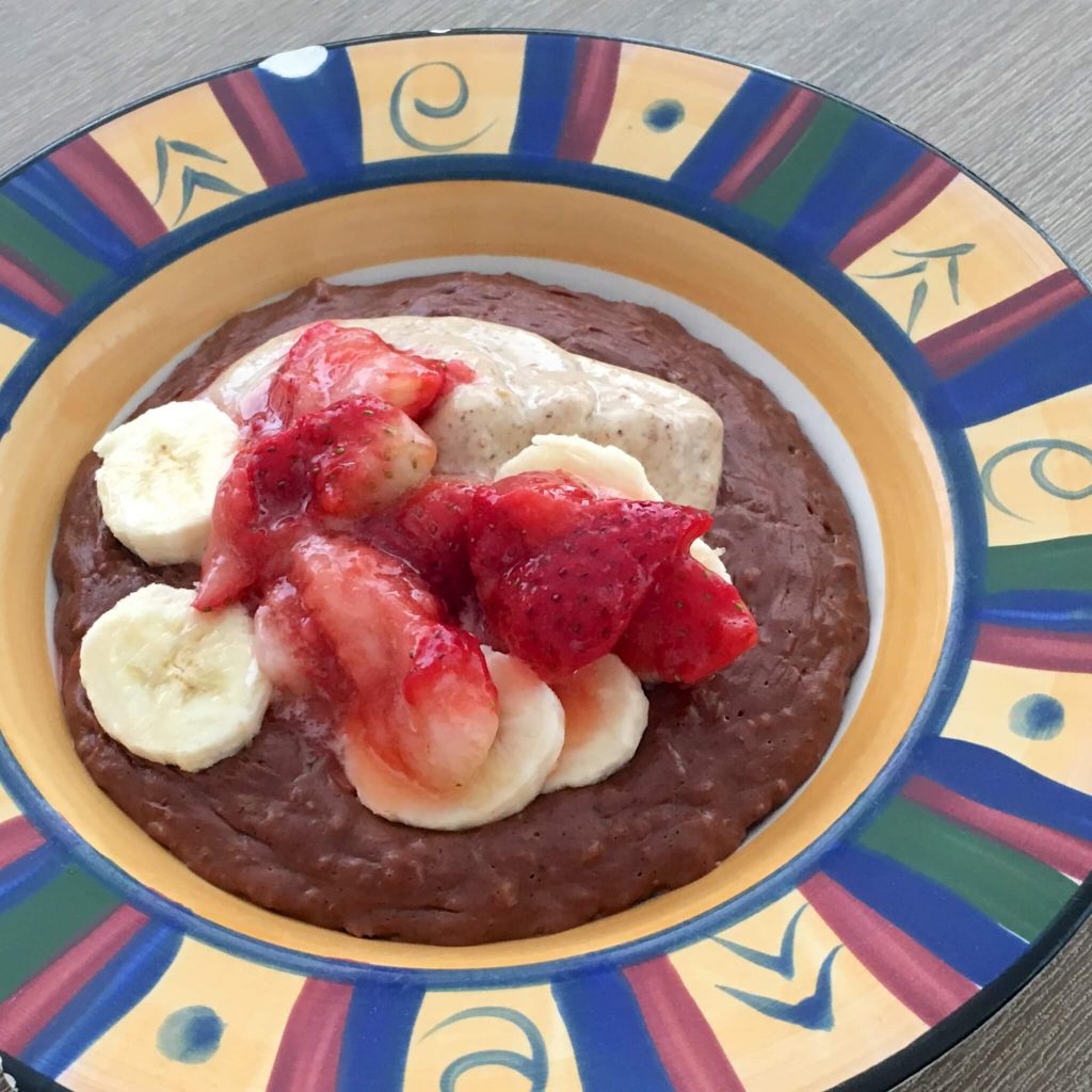 choc nut butter porridge topped with banana and strawberries