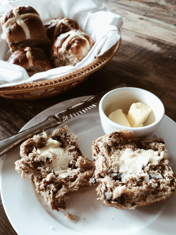 A buttered hot cross bun on a plate can be a healthy Easter treat