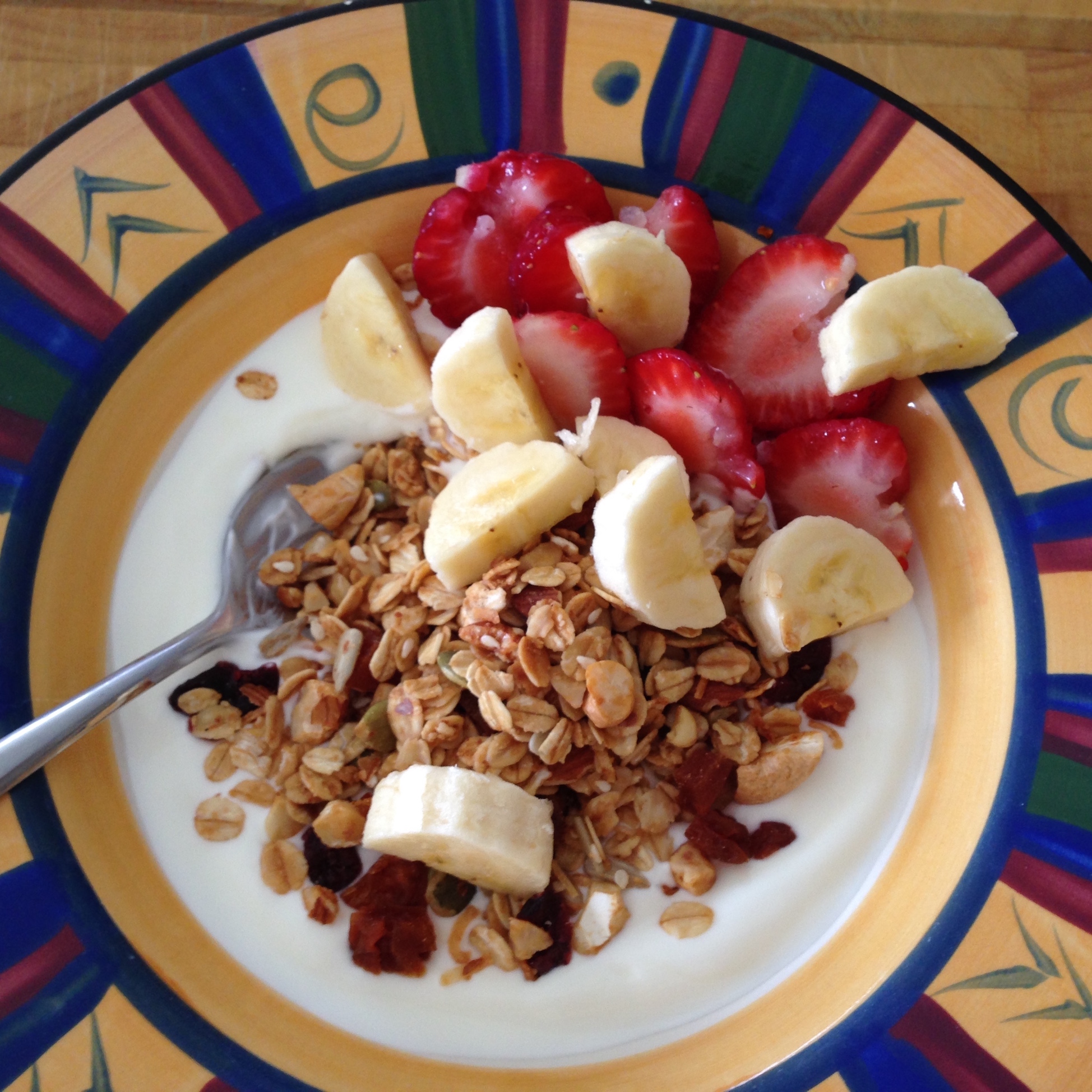 Close up of a yoghurt brekkie bowl topped with fruit and muesli