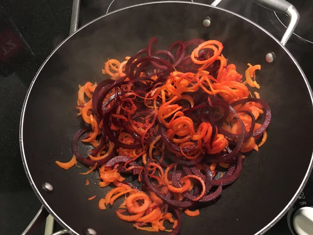 carrot and beet noodles in a wok