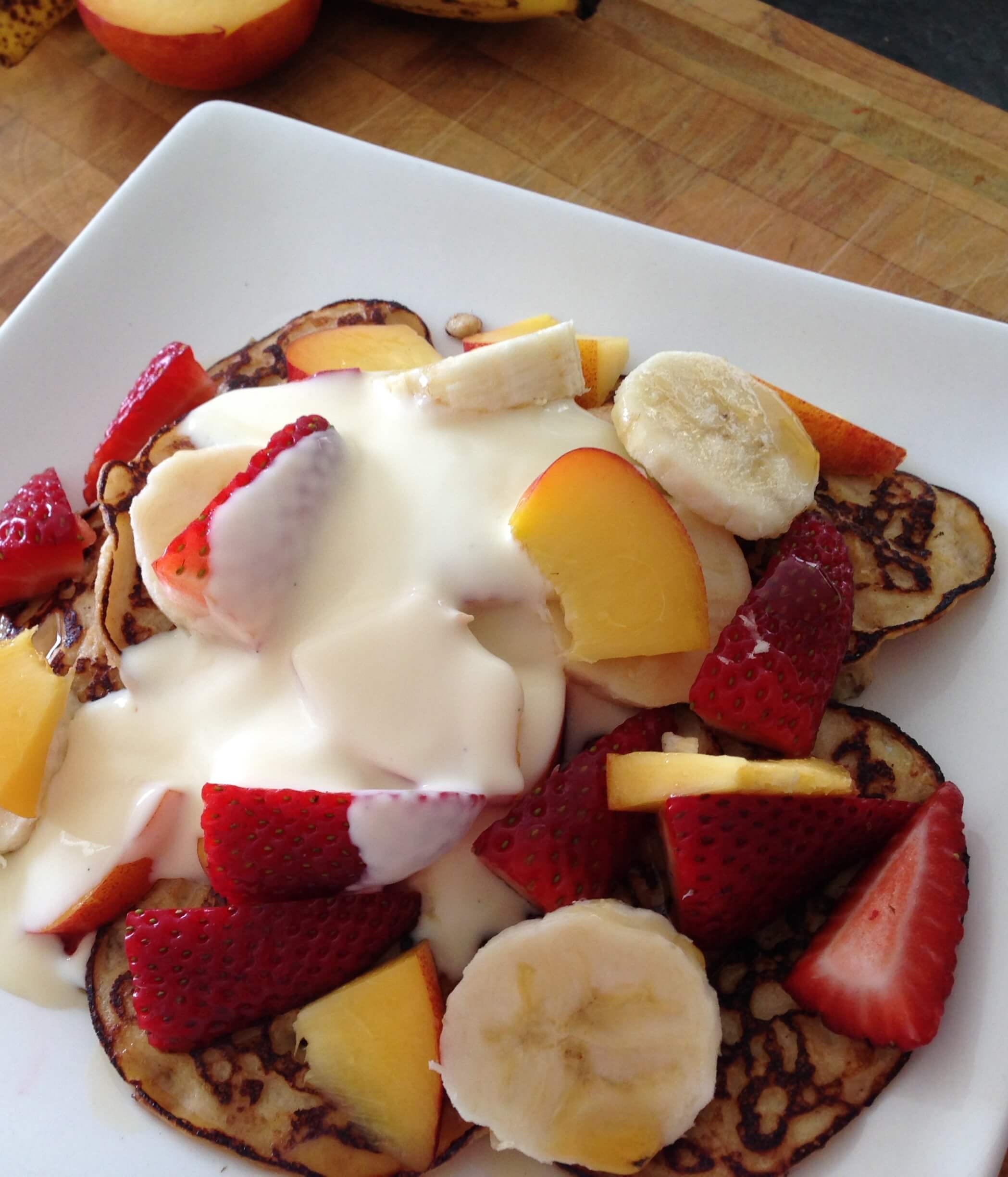 pancakes topped with strawberries, banana, nectarine and kefir