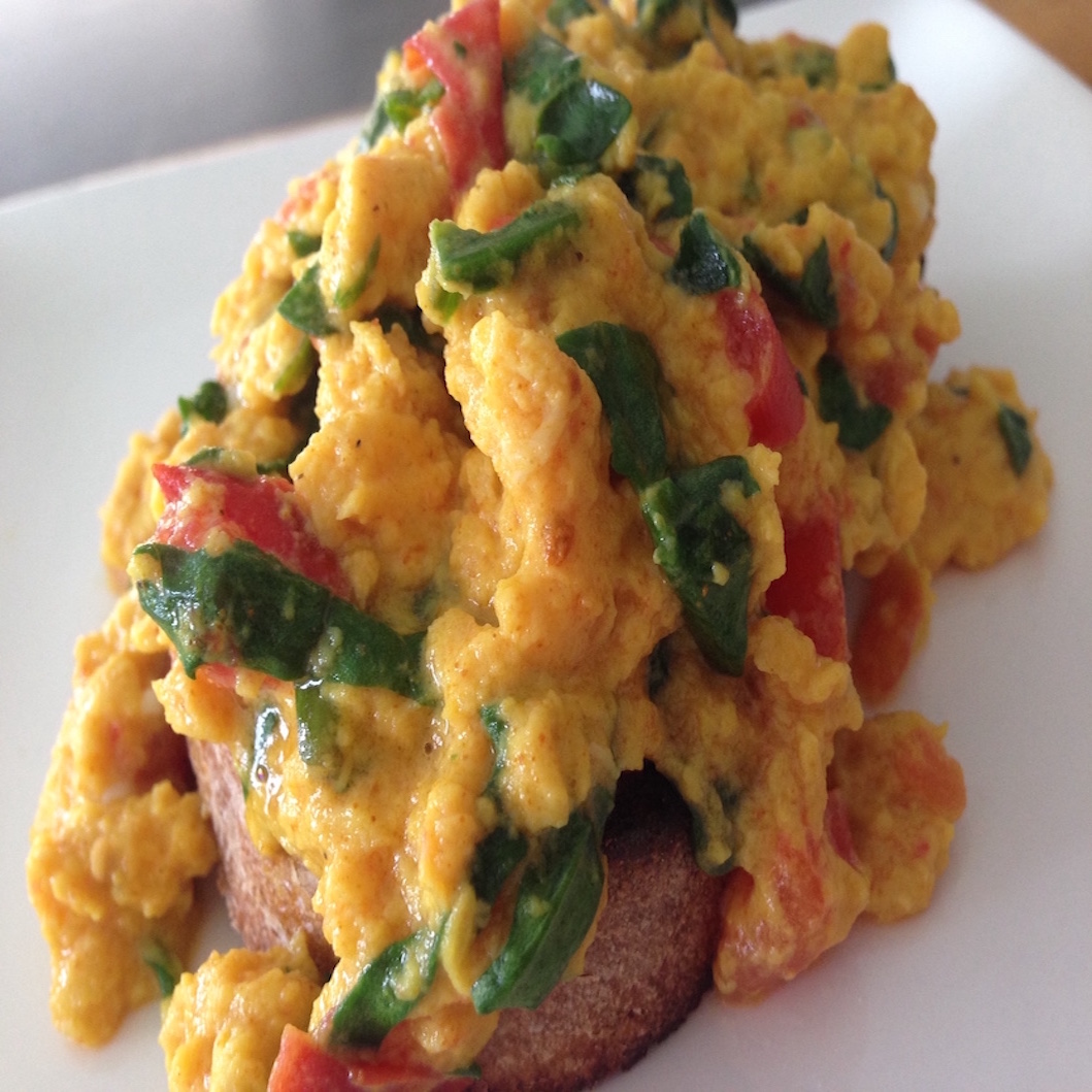 Delicious and healthy turmeric scrambled eggs with spinach and tomato