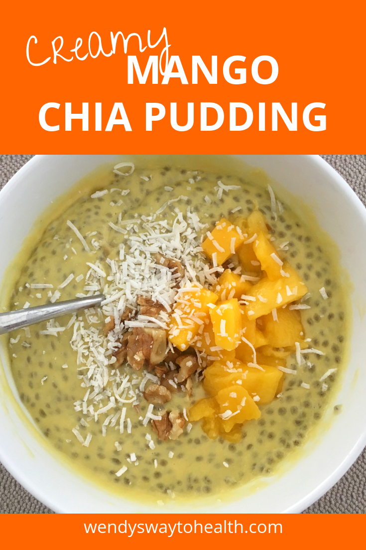 Close up of mango chia pudding, topped with mango chunks, walnuts and coconut
