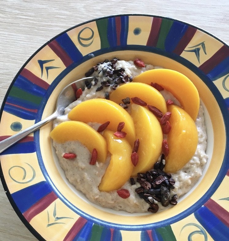 Coconut milk porridge with peaches and cacao nibs