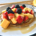 Healthy pancakes topped with fruit & maple syrup