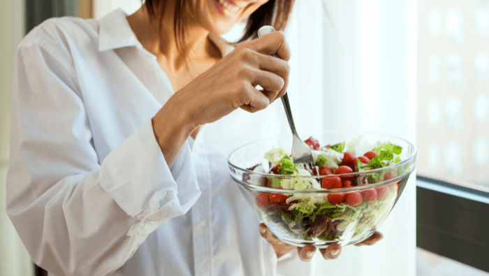 Woman eating a bowl of salad