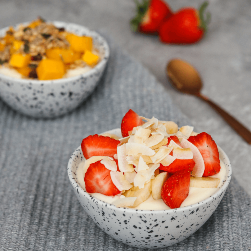High protein fruit bowl topped with strawberries and almond flakes